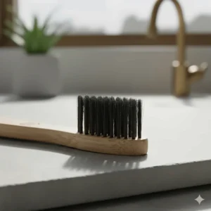 A bamboo toothbrush with black charcoal-infused bristles, highlighting natural teeth whitening and oral hygiene properties.