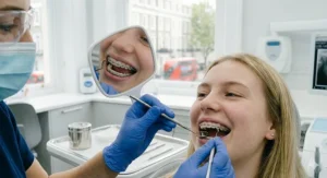 An anti-fog orthodontic inspection mirror remaining clear during a dental assessment inside a patient's mouth.