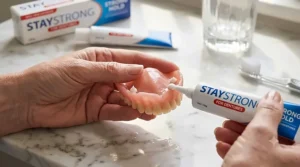 A tube of zinc-free denture adhesive, highlighting a popular choice for sensitive gums.
