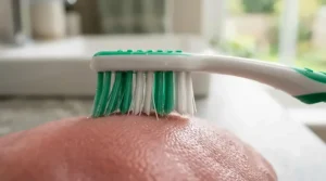 An ergonomic denture brush handle designed to improve grip and control for individuals with limited dexterity.