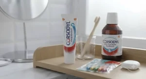 Complete daily oral care set including toothpaste for bleeding gums, mouthwash, and interdental brushes on a bathroom shelf.